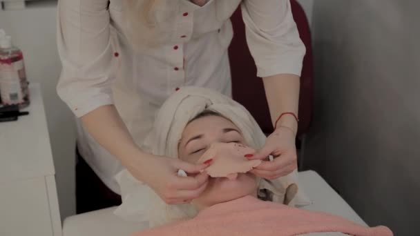 Esteticista profissional remove a máscara do rosto de uma jovem. Novo conceito em cosmetologia
. - Filmagem, Vídeo