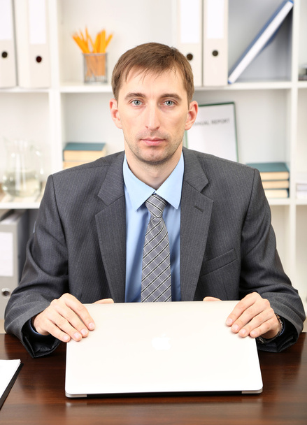 Young businessman with laptop computer shouting down on his workplace - Foto, immagini