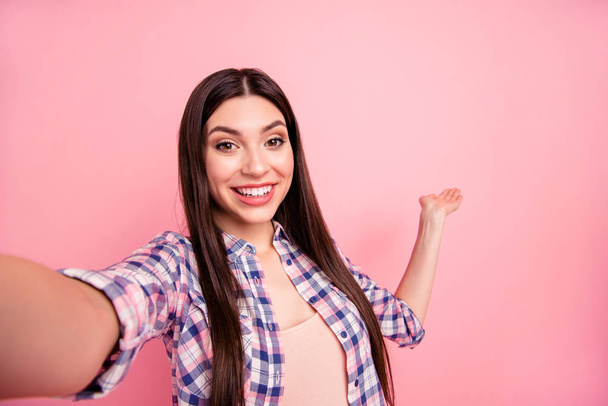 Self-portrait of her she nice-looking attractive cute charming winsome lovely cheerful cheery straight-haired lady wearing checked shirt holding copy space on palm isolated on pink background - Foto, Imagen