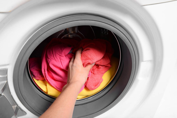 Frau legt schmutzige Wäsche in Waschmaschine, Nahaufnahme - Foto, Bild
