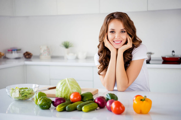 Portrait of her she nice-looking attractive sweet charming lovely cheerful wavy-haired girl making house work fresh lunch dinner farm organic vegs in light white interior room - Foto, afbeelding