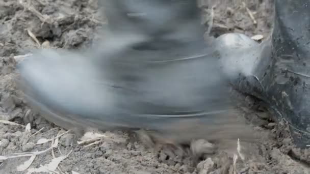 Botas de goma para hombre en suelo húmedo y fangoso sucio
 - Metraje, vídeo