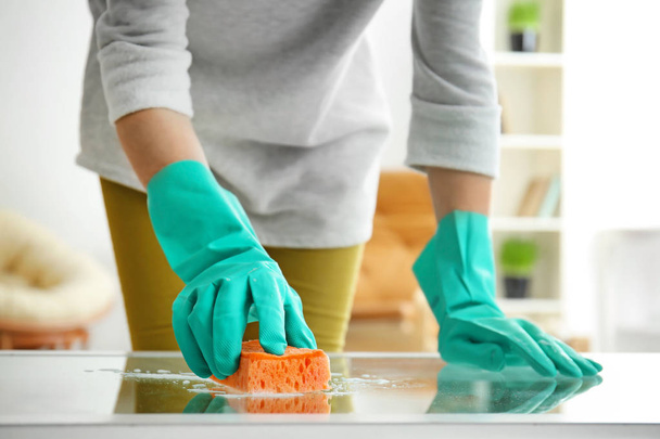 Młoda kobieta czyszczenia szkła tabeli w domu - Zdjęcie, obraz