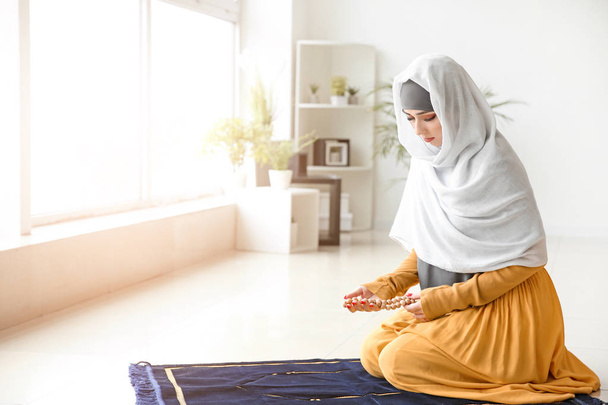 Young Muslim woman praying at home - Fotoğraf, Görsel