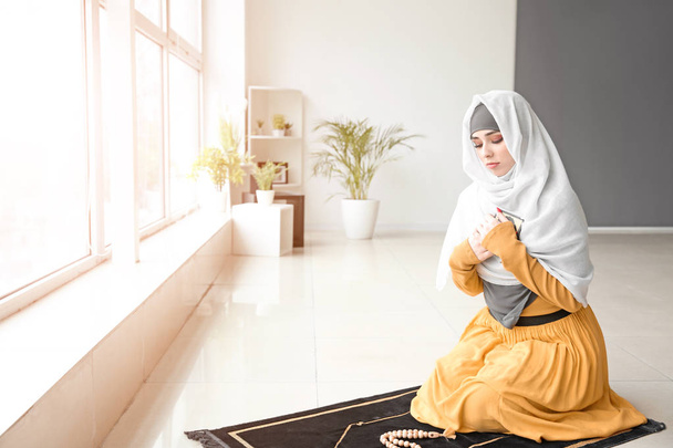 Mujer musulmana joven rezando en casa
 - Foto, imagen