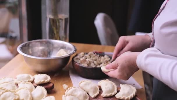 Close up vrouwelijke handen maakt knoedels met gehakt vlees. vrouwelijke kok snel en vakkundig maakt dumplings, Vareniki-nationale Oekraïense schotel, traditionele Oekraïense keuken. - Video