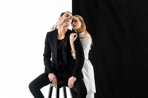 Model wearing white clothes touching face of her colleague - 写真・画像