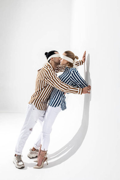Chemises et bandeaux. Jeunes mannequins créatifs portant des chemises rayées et les yeux bandés posant ensemble
 - Photo, image