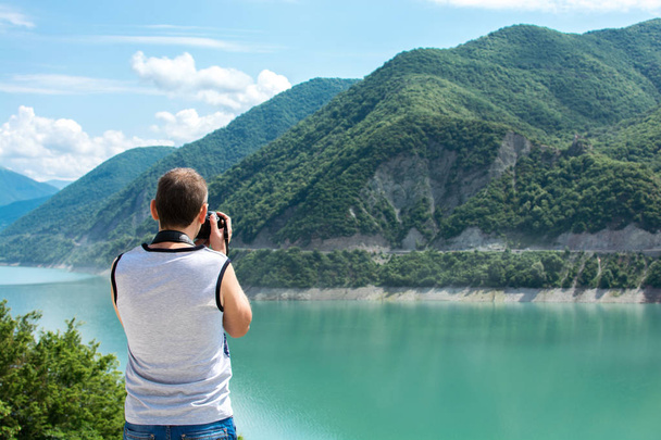 Turysta jest fotografowanie piękny widok na zbiornik Inguri w Swanetii. Gruzja. - Zdjęcie, obraz