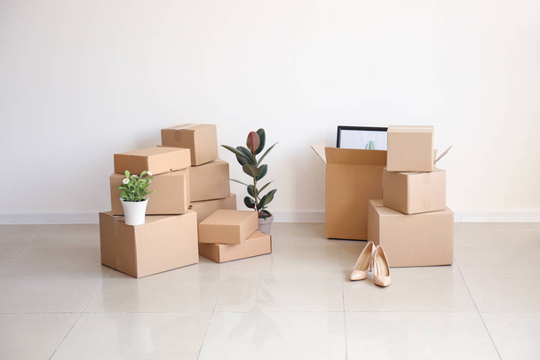 Caixas móveis com pertences em sala vazia
 - Foto, Imagem