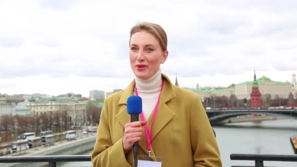 Young girl TV reporter is broadcasting on modern city background - Footage, Video