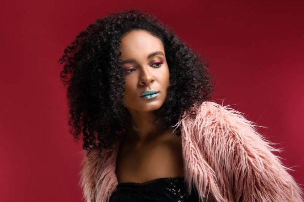 Portret van mooie Afro-Amerikaanse vrouw met ongewone make-up op kleur achtergrond - Foto, afbeelding