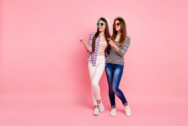 Full length body size photo of cute funky students advise choose choice have ad averts look give feedback, suggest sales demonstrate discounts dressed shirts jeans isolated pink background  - Foto, immagini