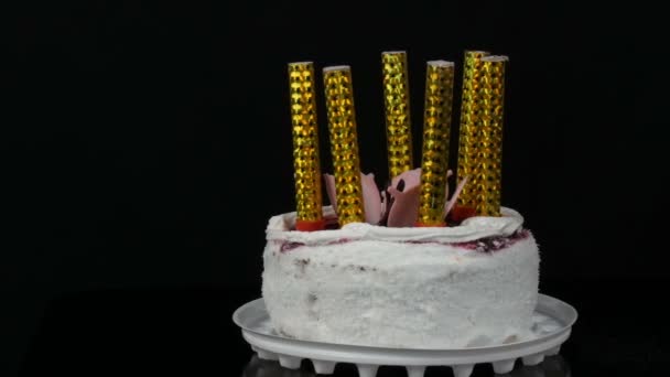 Kaarsen op een mooie stijlvolle zoete verse witte cake met cherry jam versierd met room en kokos vlokken op de top. Verjaardagstaart op zwarte achtergrond. - Video