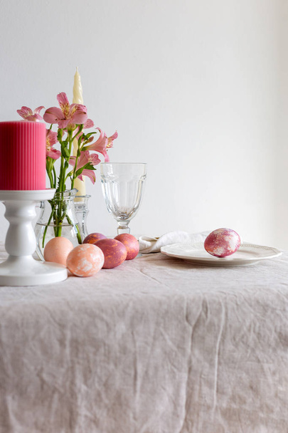 Easter table set on linen tablecloth with Easter egg on plate with decor. - Fotó, kép