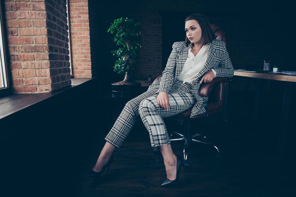 Full length body size photo beautiful amazing she her business lady look side clever candid eyes sit big cozy comfort chair near window sill office wear formal-wear checkered plaid suit - Фото, изображение