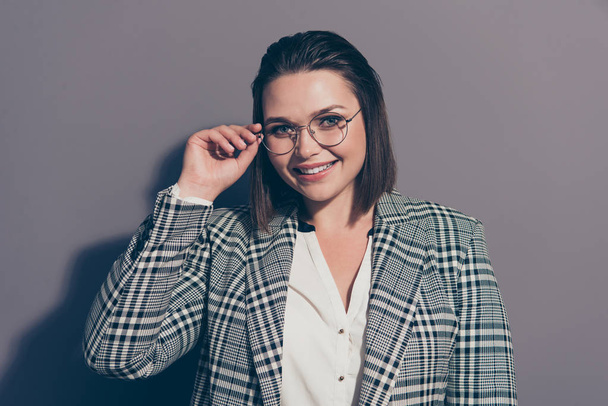 Close-up portrait of her she nice-looking beautiful attractive classy cheerful experienced lady wearing checked blazer touching glasses career promotion isolated over gray pastel background - Foto, Imagem