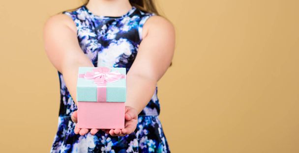 Share and generosity. Thank you so much. Child hold gift box beige background. Kid girl delighted gift. Girl adorable celebrate birthday. Kid happy loves birthday gifts. Shopping and holidays - Foto, Imagen
