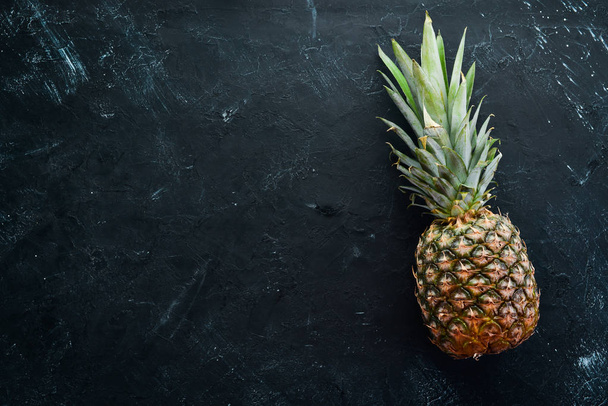 Fresh pineapple on a black stone background. Top view. Free copy space. - Fotoğraf, Görsel