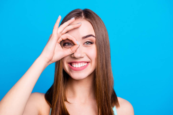 Close up photo of pretty carefree playful student trendy placing fingers near eye recommending choosing deciding suggesting giving options isolated on colorful background - Foto, Imagem