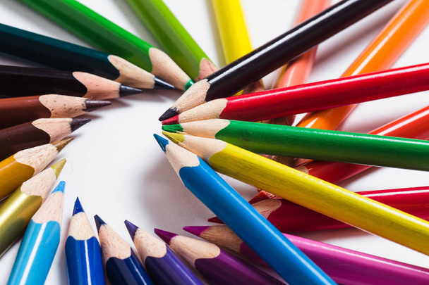Colored pencils are lying in a circle on a white background - Fotó, kép