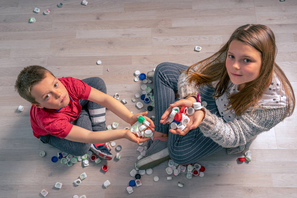 gyermekek újrahasznosítása üvegek és műanyag sapkák, vicces hozzáállás - Fotó, kép