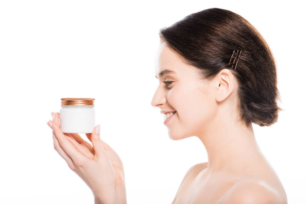 young woman holding container with face cream and smiling isolated on white  - Foto, Imagen
