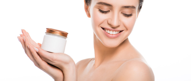 panoramic shot of young woman holding container with face cream and smiling isolated on white  - Φωτογραφία, εικόνα
