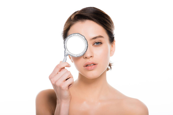přitažlivá nahá žena pokrývající oko se zrcadlem izolovaným na bílém  - Fotografie, Obrázek