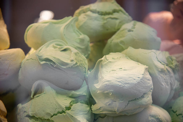 The meringue or spumiglia or cooked meringue is a sweet preparation based on egg whites and icing sugar. Soft, light pastry, made of crumbly and spongy paste, white and green. - Photo, Image