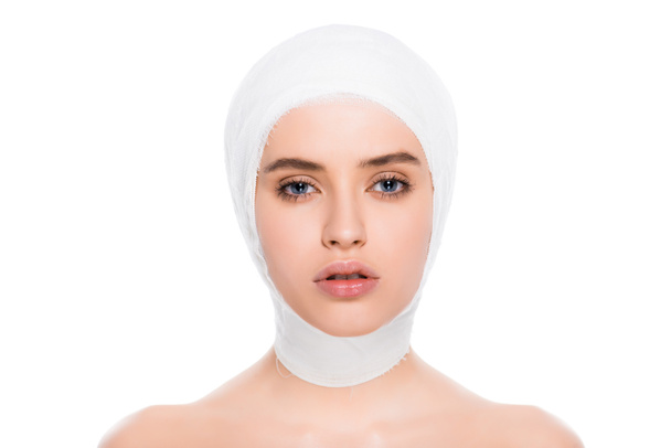 beautiful young woman with bandaged head looking at camera isolated on white  - Photo, Image