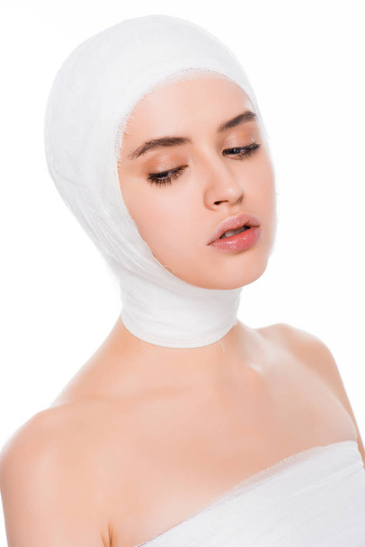 白に分離された整形手術後に包帯をした頭を持つ若い女性  - 写真・画像