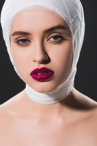 close up of beautiful girl with bandaged head looking at camera isolated on grey  - Foto, Imagem