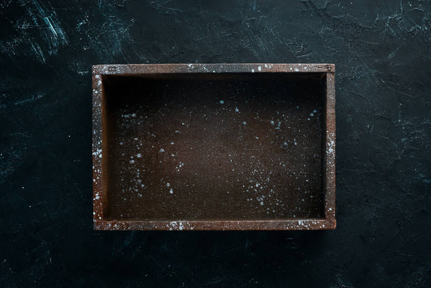 Old wooden black box. On a black stone background. Top view. Free copy space. - Fotó, kép