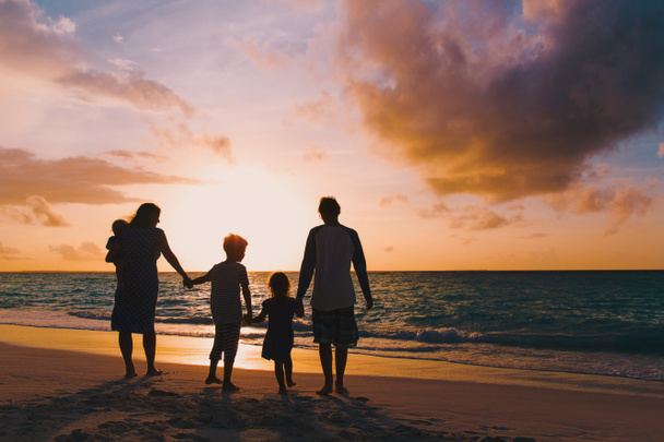 famiglia felice con albero bambini passeggiata sulla spiaggia al tramonto - Foto, immagini