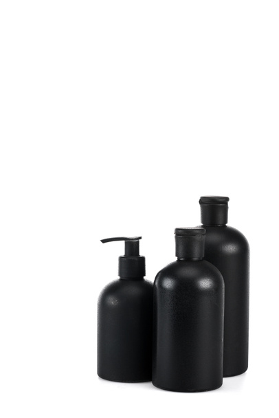 Bottiglie cosmetiche nere con spray e tappi isolati su bianco
 - Foto, immagini