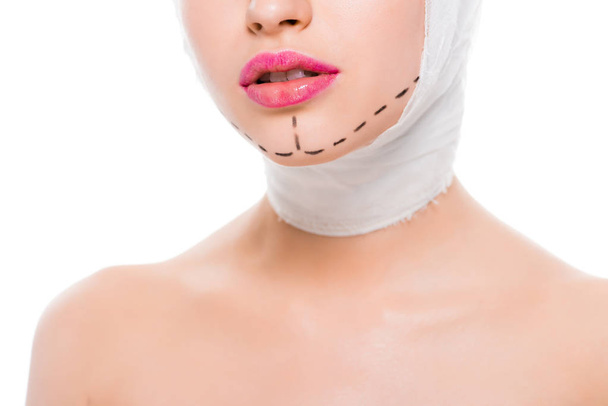 白い上に孤立した顔に包帯の頭とマークを持つ女性のクロップビュー  - 写真・画像