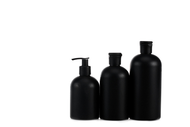Black cosmetic bottles with spray and caps isolated on white - Photo, Image