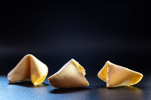 Fortune cookies on black background broken without message. - Photo, Image