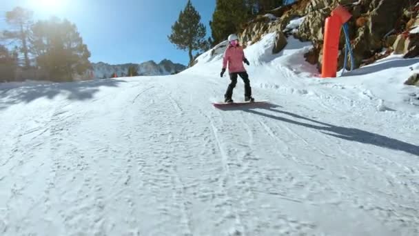 Fiatal csípő női snowboardos a napos lejtőn - Felvétel, videó