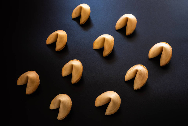 Fortune cookies on dark background arranged symmetrically - Foto, Imagen