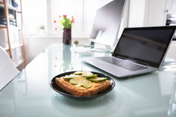Healthy Sandwich In Plate Near Laptop Over Reflective Desk - Photo, Image