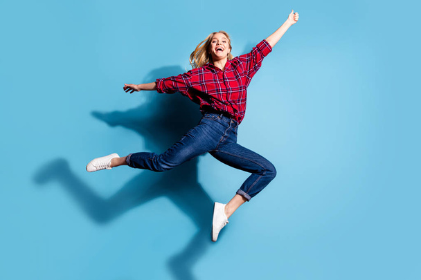 Full length body size view portrait of nice attractive cheerful cheery girl wearing checked shirt holding invisible thing having fun isolated on turquoise bright vivid shine background - Fotó, kép