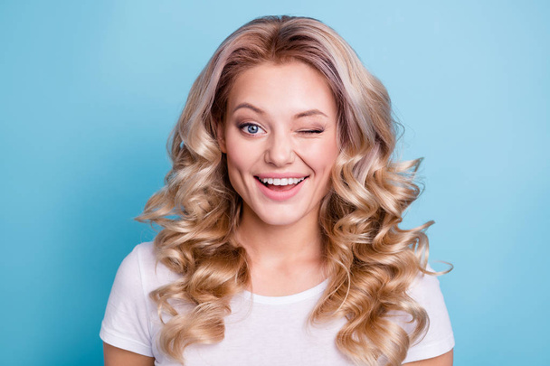 Close up photo pretty beautiful amazing wonderful her she lady wave wealth hair styling shiny look blinking one eye wearing casual white t-shirt clothes outfit isolated bright blue background - Foto, Imagen