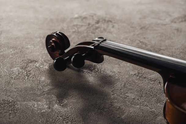 крупним планом струни на класичній віолончелі на сірому текстурованому фоні
  - Фото, зображення