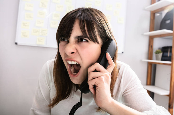 Portrait Of A Shocked Businesswoman Talking On Telephone - Fotó, kép