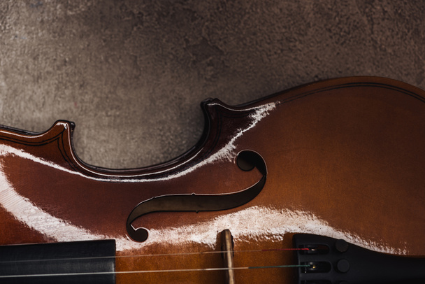 top view of classical wooden cello on grey textured surface in darkness - Foto, immagini