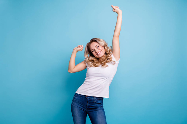 Close up photo beautiful amazing her she lady satisfied lucky facial expression hands arms palms fists raised above head wear casual white t-shirt jeans denim clothes isolated blue background - 写真・画像