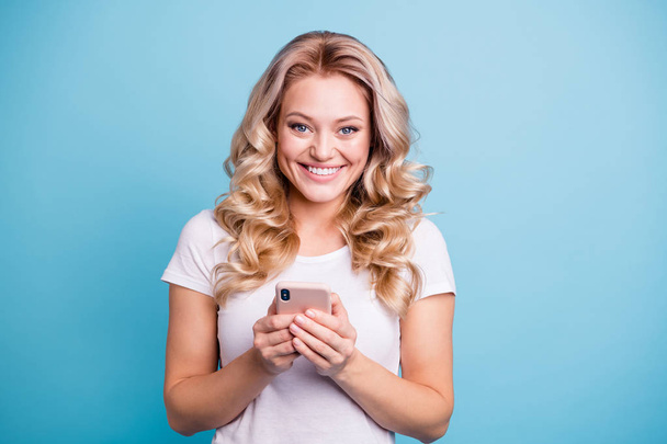 Close-up portrait of her she nice-looking lovely winsome attractive cheerful cheery wavy-haired lady holding in hands cell fast speed app isolated over blue pastel background - Foto, Bild