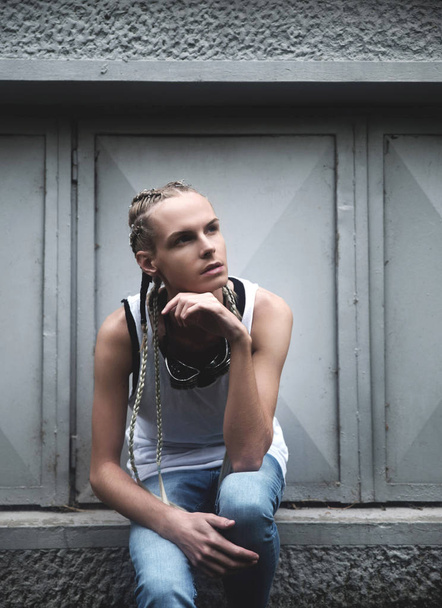 Fashionable man with braided hair against gray wall - 写真・画像